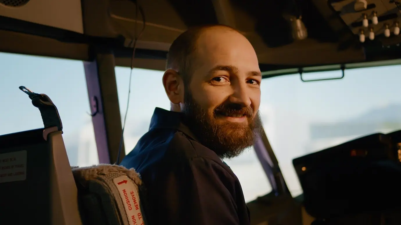 Porträt eines Flugkapitäns, der über das Bedienfeld Start- und Flugkommandos ausführt, Leistungsschalter betätigt und den Schubhebel reguliert. Instrumententafel im Cockpit zur Navigation. Handkameraaufnahme.