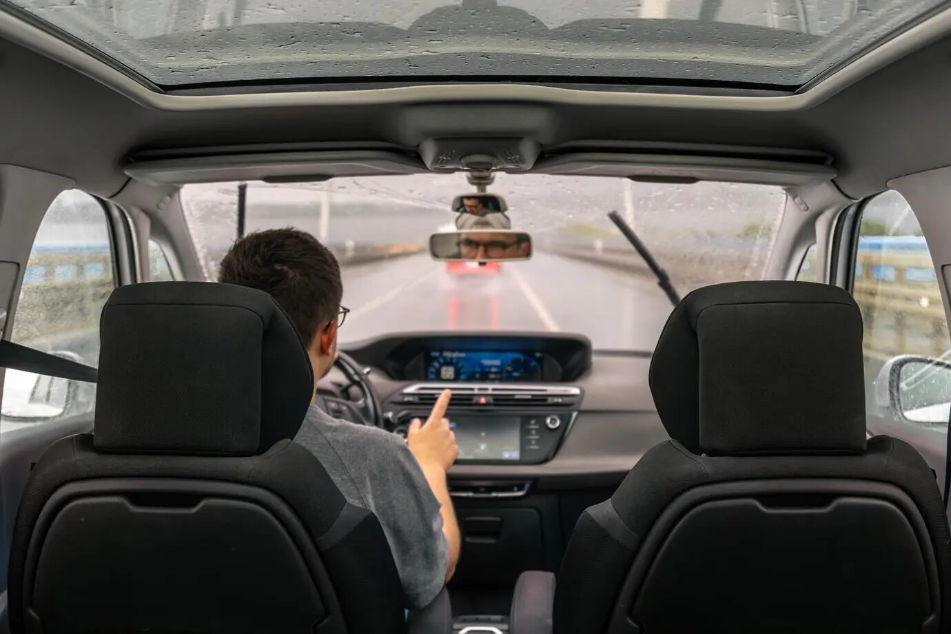 Geste des Fahrers, Fahrt im Regen, Armaturenbrett des Autos