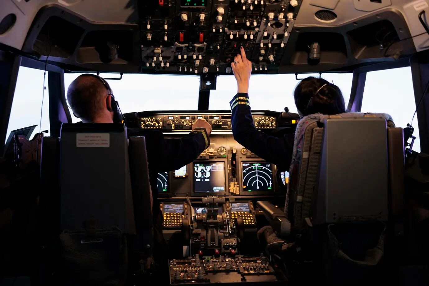 Kapitän und Kopilotin bereiten sich im Cockpit mithilfe der Navigationsinstrumente auf Flug und Start vor. Die Flugbesatzung stellt die Flughöhe über die Tasten am Bedienpanel ein und fliegt das Flugzeug.